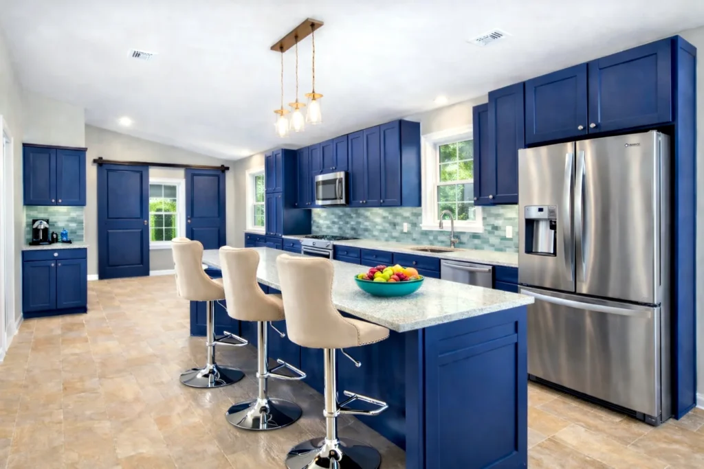 Outer Banks kitchen remodel with navy blue cabinets, large island, stainless appliances, and light gray walls.